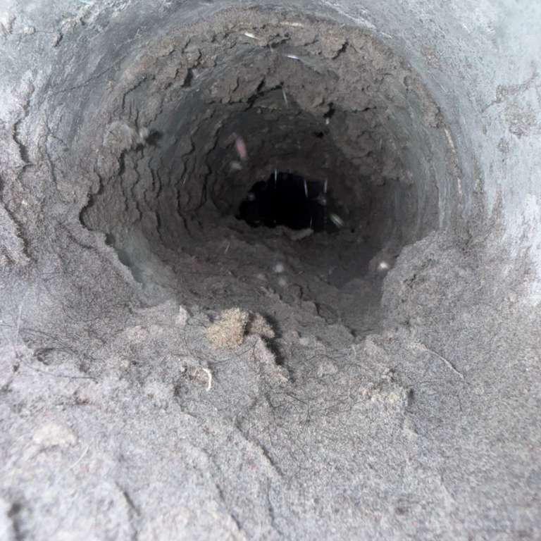 Inside an air duct before cleaning — heavy dust, lint and buildup